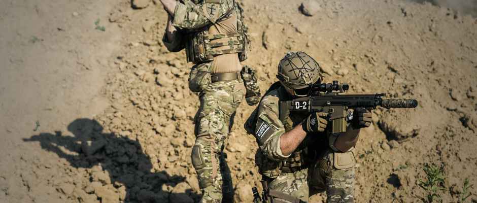 two men in army uniforms with guns